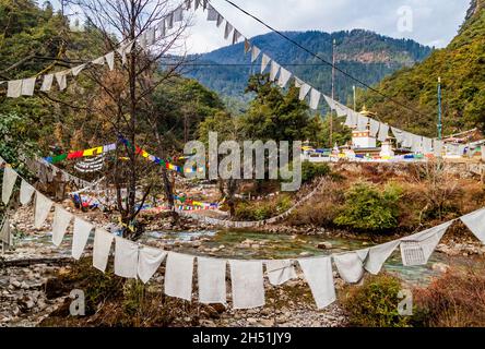 Prière traditionnelle drapeaux bouddhistes tibétains multicolores Lung Ta au-dessus de la rivière au Bhoutan dans la vallée de la rivière Thimphu. Banque D'Images