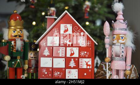 Calendrier de l'Avent des arbres en bois devant un véritable arbre de Noël décoré casse-noisette Soldier Toys.Lumières de fées sur un arbre de Noël avec Backgro flou Banque D'Images