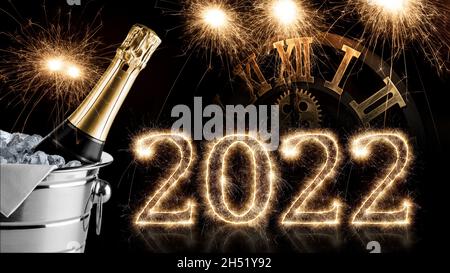 2022 sparkler avec horloge et bouteille de champagne dans un réfrigérateur sur fond noir. happy new year eve sombre Banque D'Images