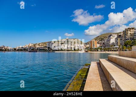 Vue panoramique sur la baie de Saranda, la ville et le port de la ville le long de la côte, Albanie.Jour d'été ensoleillé.De beaux nuages dans le ciel.Mer bleue calme. Banque D'Images