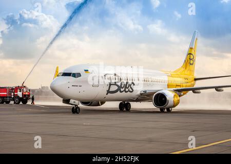 Avion jaune de la compagnie aérienne Bees sur le tablier.Boeing 737-800 UR-UBA avion de tourisme.Après la pluie et le lavage.Copier piste d'espace.Ukraine, Kiev - 19 mars 2021. Banque D'Images