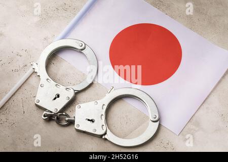 Drapeau du Japon et menottes sur la table, concept de la criminalité nationale Banque D'Images