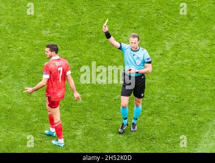 Saint-Pétersbourg, Russie – 16 juin 2021.L'arbitre néerlandais Danny Makkelie montrant une carte jaune au milieu de terrain russe Magomed Ozdoyev pendant L'EURO 2020 mat Banque D'Images