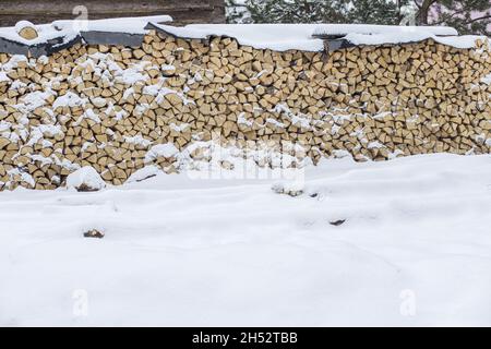 Bois de chauffage empilé en hiver.Pile de bois avec neige empilée pour le bois de chauffage.Bois de chauffage haché sous la neige.Des tas de neige couvraient le bois de chauffage à froid Banque D'Images