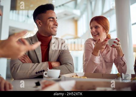 un homme riant à une blague drôle avec une équipe de travail diversifiée de coworkers.friendly appréciant au déjeuner ensemble Banque D'Images