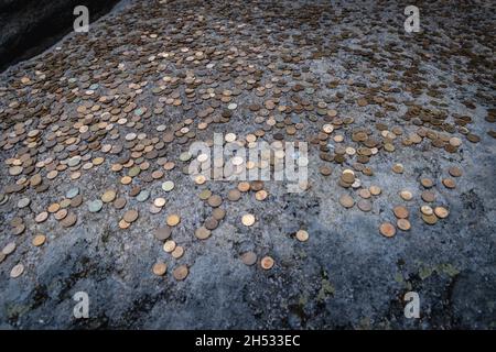 Pièces laissées par les touristes sur un lit de nuit dans le sanctuaire rupestre préhistorique de Beglik Tash situé sur la côte sud de la mer Noire en Bulgarie Banque D'Images