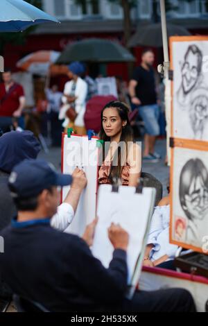 Paris, France - juillet 2019 : peintre de Montmartre représentant une belle femme asiatique sur la place du Tertre, à quelques rues du Basil de Montmartre Banque D'Images