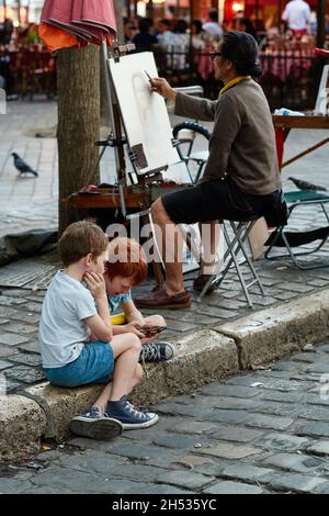 Paris, France - juillet 2019 : le peintre de Montmartre dessine un portrait sur la place du Tertre, à quelques rues de la basilique du Sacré-cœur de Montmartre Banque D'Images