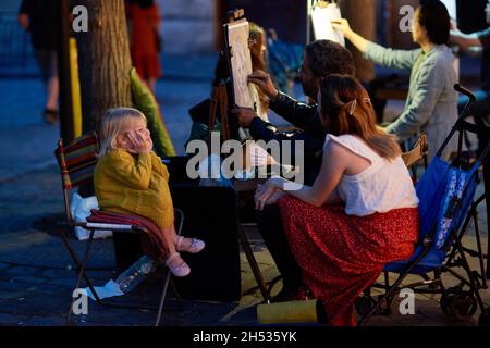 Paris, France - juillet 2019 : peintre de Montmartre présentant un enfant à la place du Tertre la nuit, à quelques rues de la basilique de Montmartre Banque D'Images