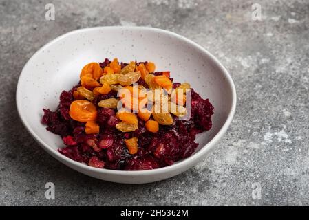 Salade de betteraves avec pruneaux dans assiette vegan gros plan Banque D'Images