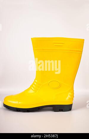 Bottes en caoutchouc jaune robustes et étanches isolées sur fond blanc Banque D'Images