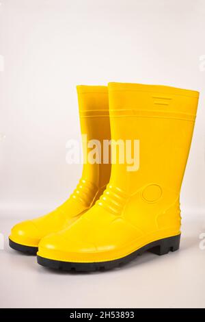 Bottes en caoutchouc jaune robustes et étanches isolées sur fond blanc Banque D'Images