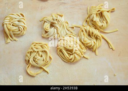 tagliatelle aux œufs fait à la main sur un plateau de pâtisserie en bois Banque D'Images