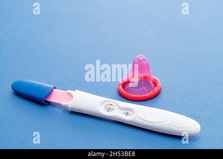 Un test de grossesse positif avec un condom Banque D'Images
