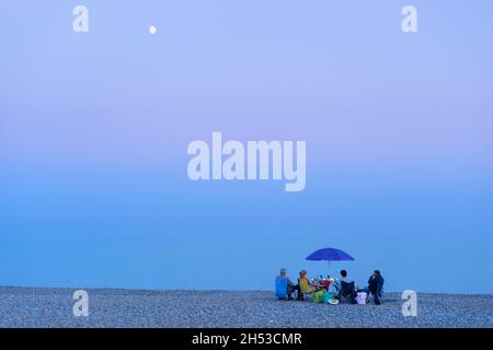 Seaton Beach Seaton Devon Une famille sur la plage ayant un pique-nique en soirée sur Seaton Beach Seaton Devon Angleterre GB Europe Banque D'Images