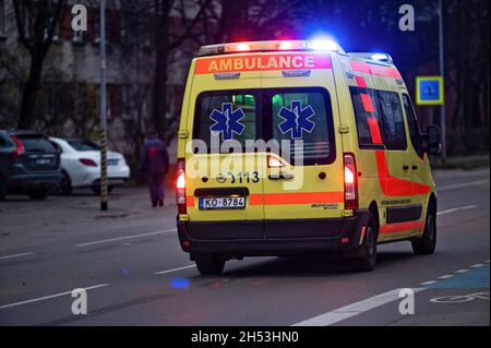 Riga, Lettonie, 2 novembre 2021 : minibus jaune vif avec balises et sirènes sur la ville le soir, vue arrière Banque D'Images