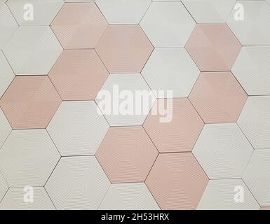 Mur de carreaux hexagonaux blanc et rose clair, avec détails hexagonaux à l'intérieur de chaque carreau.Plein écran. Banque D'Images