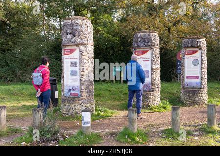 Un homme et une femme lisant des informations sur les visiteurs dans trois colonnes verticales sur les murs de la ville romaine de Silchester (Calleva Atrebatum).Hampshire, Royaume-Uni Banque D'Images