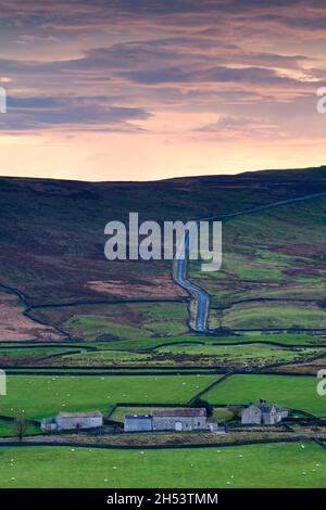 Vallée de la Wharfedale (bâtiments agricoles, murs en pierre sèche, champs agricoles, route de campagne, hautes terres émergées,Coucher du soleil) - Yorkshire Dales, Angleterre Royaume-Uni. Banque D'Images