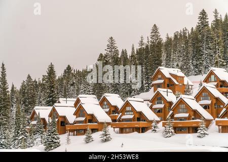 Big Sky, MT, US - 8 février 2020 : appartements de ski couverts de neige sur le flanc d'une montagne près d'une station de ski. Banque D'Images