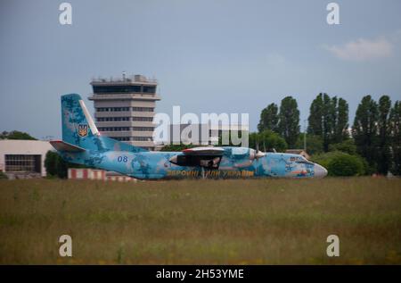 UKRAINE, KIEV, - 28 MAI 2021 : AN-26 de l'avion des forces armées ukrainiennes sur la piste de l'aéroport.Avion volant.Nuages de tempête sombre le soir.Ciel spectaculaire.Tablier et terminal Aiport. Banque D'Images