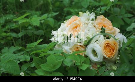 Bouquet de belles roses sur fond d'herbe verte.Attache.Un bouquet de roses dans l'herbe. Banque D'Images