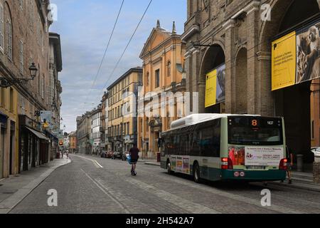 Vue sur la rue de la vieille ville avec un bus public et un scooter électrique passant devant l'hôtel de ville par une journée nuageux, Parme, Emilie-Romagne, Italie Banque D'Images