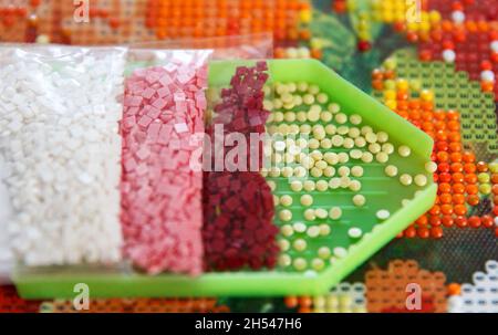 Strass multicolores dans un contenant pour le processus de création fait main de peinture 3D de diamants à partir de rhinestones Banque D'Images