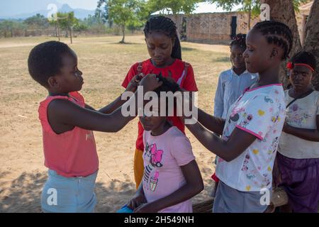 Les petites filles braquent les cheveux de leur ami Banque D'Images