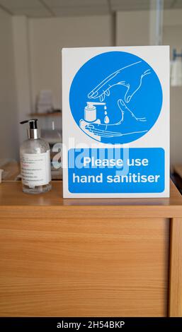 Norwich, Norfolk, Royaume-Uni – novembre 05 2021.Affiche conseillant aux visiteurs de se désinfecter les mains et d'utiliser une bouteille de désinfectant pour les mains pendant la pandémie de Covid Banque D'Images