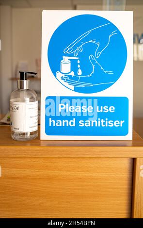 Norwich, Norfolk, Royaume-Uni – novembre 05 2021.Affiche conseillant aux visiteurs de se désinfecter les mains et d'utiliser une bouteille de désinfectant pour les mains pendant la pandémie de Covid Banque D'Images