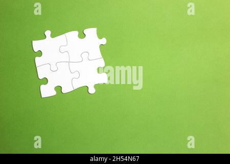 Quatre pièces de scie sauteuse blanches assemblées pour former un groupe de tous les côtés. Fond vert. Espace de copie. Ensemble de travail. Espace pour les lettres et le texte. Banque D'Images