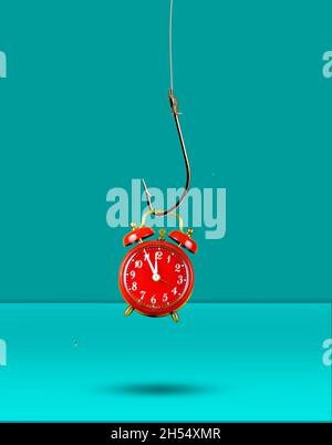 Horloge rouge accrochée à un crochet de pêche.Le temps est écoulé, de cinq minutes à douze heures.Concept de temps. Banque D'Images