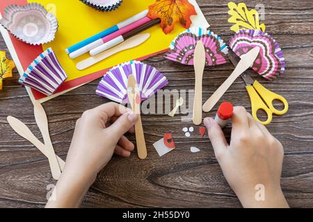 Instructions, étape 6.Jouet de Thanksgiving stics marionnettes dinde sur table en bois.Fait à la main.Projet de créativité, d'artisanat, d'artisanat pour les enfants. Banque D'Images