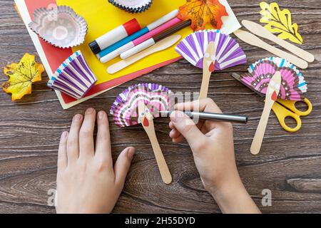 Instructions, étape 7.Jouet de Thanksgiving stics marionnettes dinde sur table en bois.Fait à la main.Projet de créativité, d'artisanat, d'artisanat pour les enfants. Banque D'Images