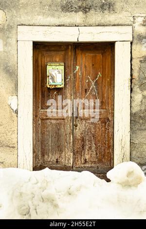 Ancienne porte en bois à moitié recouverte de neige Banque D'Images