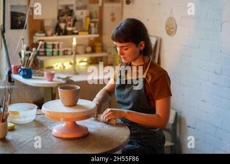 Femme détendue passez la soirée dans un studio de poterie occupé avec des travaux manuels après le stress au travail.Art thérapie Banque D'Images