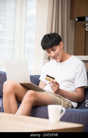 Jeune et beau homme shopping en ligne Banque D'Images