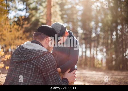 Fête du père.Triste fils embrassant papa sur le fond de la forêt avec l'espace de copie.Concept de relation père-fils Banque D'Images