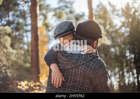 Fête du père.Triste fils embrassant papa sur le fond de la forêt avec l'espace de copie.Concept de relation père-fils Banque D'Images