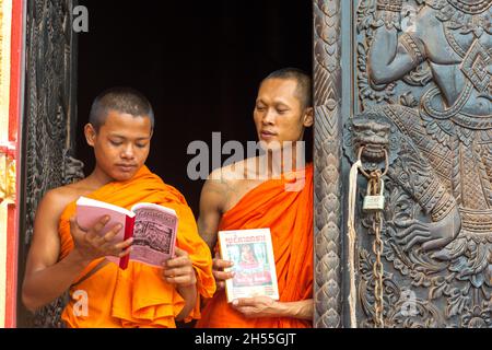Jeune moine lisant un livre sur le porche du temple Banque D'Images