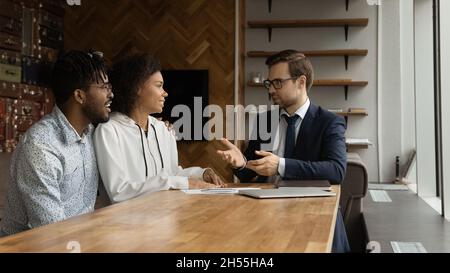Un jeune avocat intelligent consultant des clients de race mixte au bureau. Banque D'Images