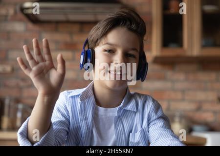 Jeune garçon d'âge scolaire dans le casque de la main à la webcam Banque D'Images