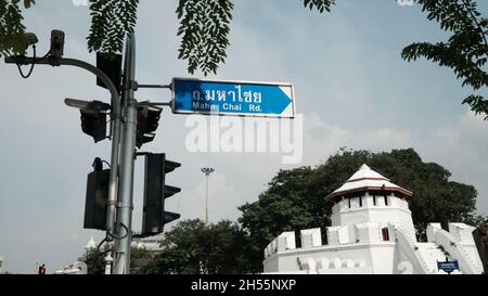 Rue signe Maha Chai Road fort de Mahakan remparts en arrière-plan Bangkok Thaïlande Banque D'Images