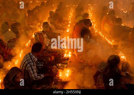 Narayanganj, Bangladesh.06e novembre 2021.Des centaines de dévotés hindous se rassemblent devant le temple Ashram Shri Shri Loknath Brahmachari pour Rakher Upobash, un festival religieux à jeun appelé Kartik Brati, à Barodi, Sonargaon, Narayanganj, Bangladesh.Assis devant les lumières de bougie, ils jeûnent et prient sincèrement aux dieux pour leurs faveurs pendant le rituel.Le festival a lieu tous les samedis et mardis dans les 15 derniers jours du mois bengali - "Kartik".(Photo de Joy Saha/Pacific Press) Credit: Pacific Press Media production Corp./Alay Live News Banque D'Images