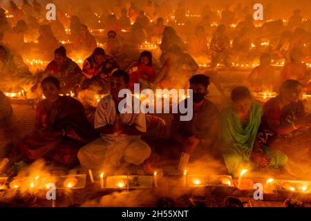 Narayanganj, Bangladesh.06e novembre 2021.Des centaines de dévotés hindous se rassemblent devant le temple Ashram Shri Shri Loknath Brahmachari pour Rakher Upobash, un festival religieux à jeun appelé Kartik Brati, à Barodi, Sonargaon, Narayanganj, Bangladesh.Assis devant les lumières de bougie, ils jeûnent et prient sincèrement aux dieux pour leurs faveurs pendant le rituel.Le festival a lieu tous les samedis et mardis dans les 15 derniers jours du mois bengali - "Kartik".(Photo de Joy Saha/Pacific Press) Credit: Pacific Press Media production Corp./Alay Live News Banque D'Images