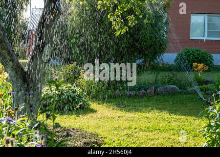 Jardin intelligent activé avec système d'arrosage automatique fonctionnant tôt le matin dans le parc vert arrosage pelouse Banque D'Images