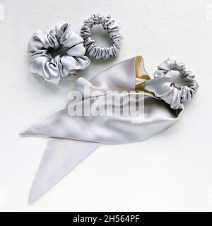 Soie argentée scindée sur blanc.Accessoires et outils de coiffure pour la pose d'un plat.Serre-tête élastique de qualité supérieure Banque D'Images