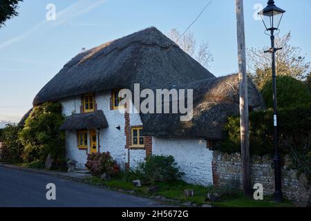 Vue sur un cottage en chaume avec portes et cadres de fenêtres peints en jaune. Banque D'Images