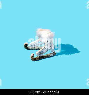 Vieux patins à glace blanc et bleu en bois sur fond bleu pastel.Concept créatif saisonnier des vacances d'hiver.Design romantique pour bannière ou carte.Rétro c Banque D'Images